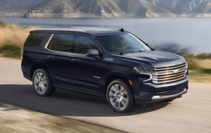 A black 2024 Chevrolet Tahoe driving down a road next to water near Parsons, Kansas