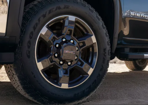 A close-up photo of the wheel of a 2025 GMC Sierra HD truck parked on a sandy road near Parsons, Kansas.