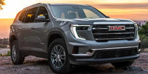 A grey 2025 GMC Acadia parked outdoors at sunset near Parsons, KS